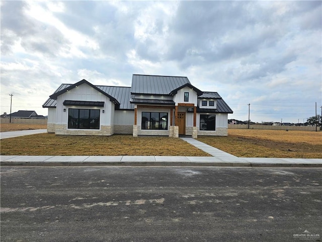 modern farmhouse style home with a front lawn