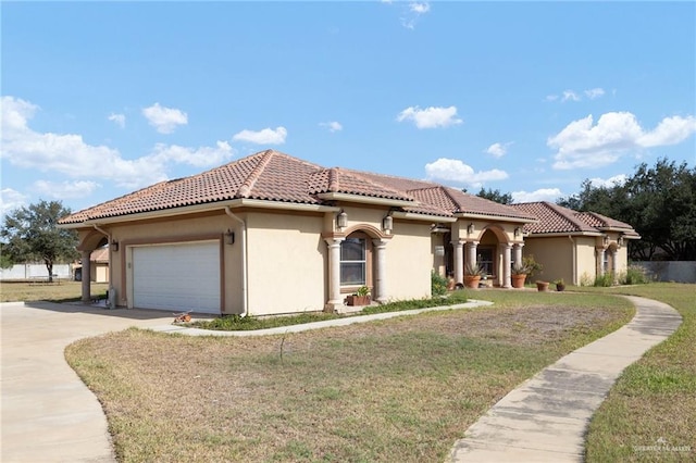 mediterranean / spanish-style home with a garage and a front yard