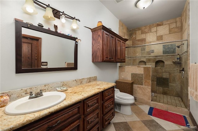 bathroom featuring tiled shower, vanity, and toilet