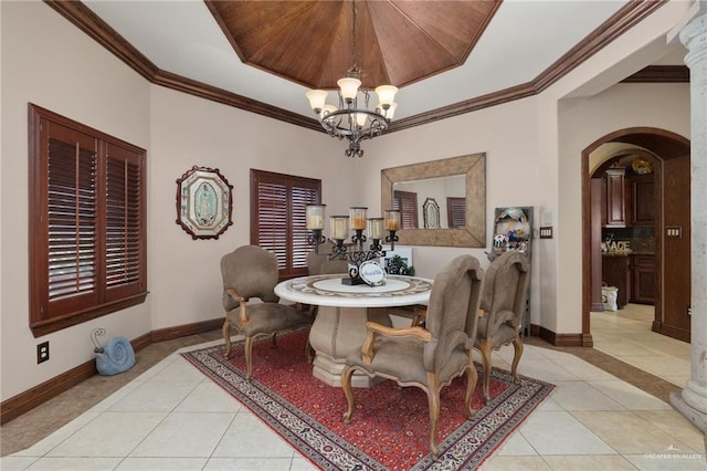 dining room with a tray ceiling, light tile patterned floors, crown molding, and an inviting chandelier