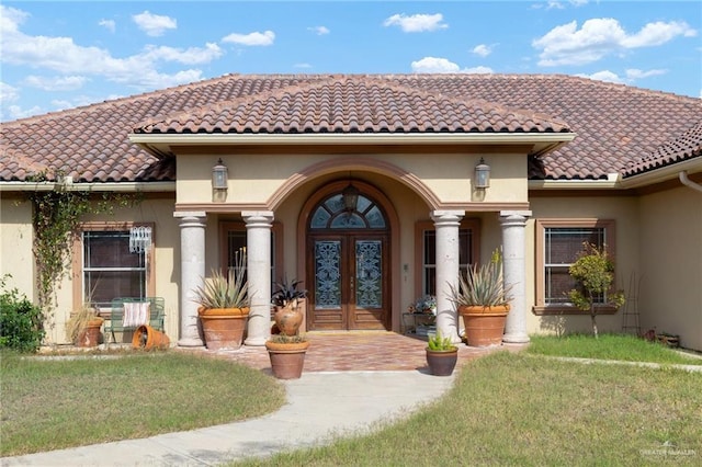 doorway to property with french doors and a lawn