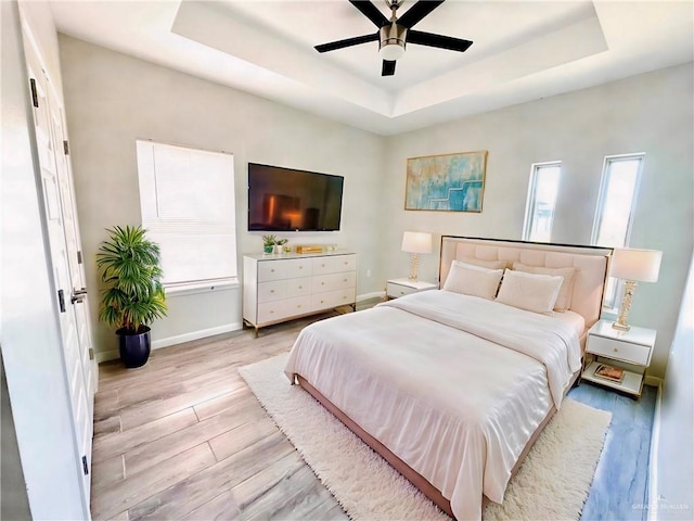 8706 Pink Flamingo St, Harlingen, TX 78552 - bedroom featuring a tray ceiling, light wood-type flooring, multiple windows, and ceiling fan