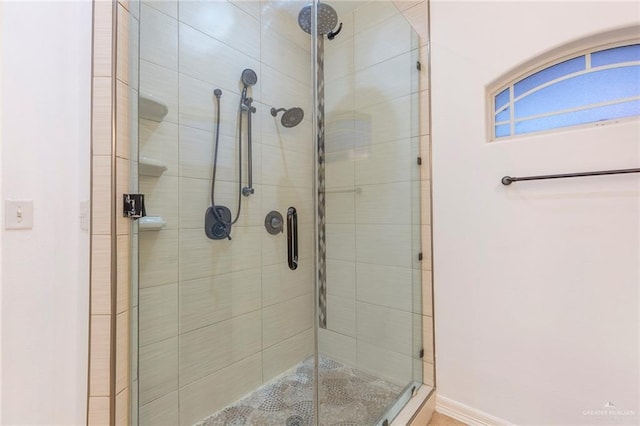 bathroom with a shower with door