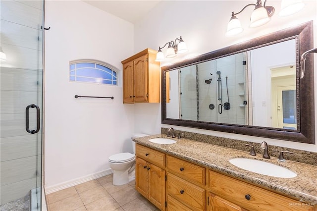 bathroom with tile patterned flooring, vanity, a shower with shower door, and toilet