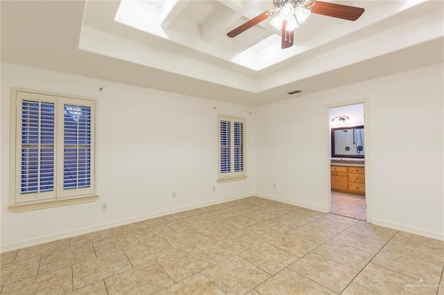 spare room featuring ceiling fan, light tile patterned floors, and a tray ceiling