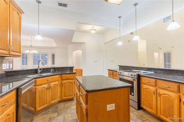 kitchen with decorative light fixtures, stainless steel appliances, a kitchen island, and sink