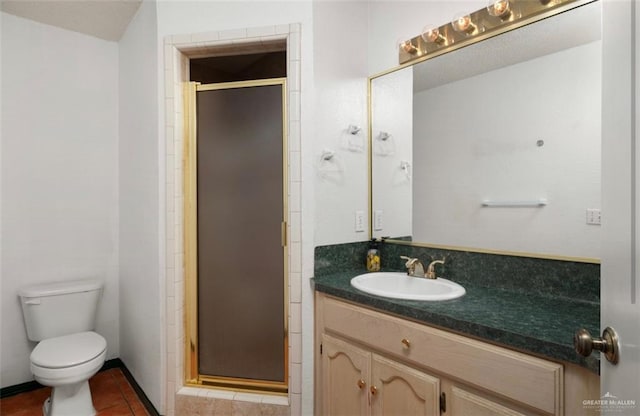 bathroom featuring tile patterned flooring, vanity, toilet, and a shower with door