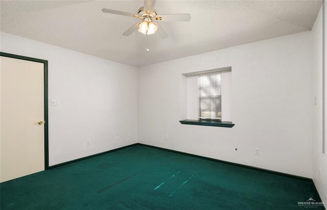 unfurnished room with a textured ceiling, dark carpet, and ceiling fan