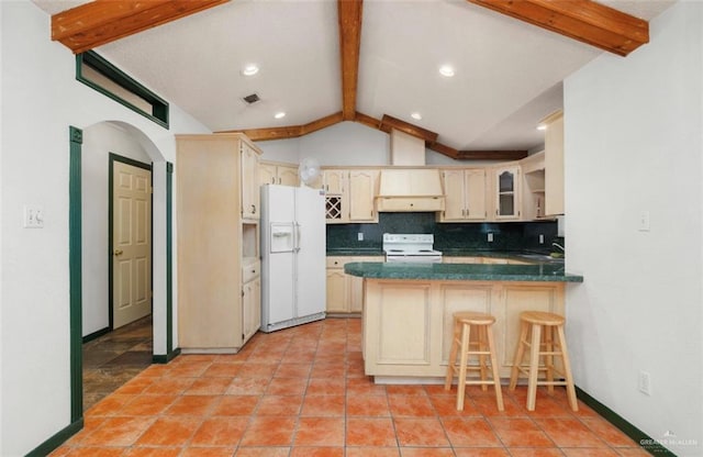 kitchen with white appliances, vaulted ceiling with beams, tasteful backsplash, cream cabinetry, and kitchen peninsula