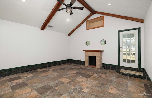 unfurnished living room with vaulted ceiling with beams, ceiling fan, and a fireplace