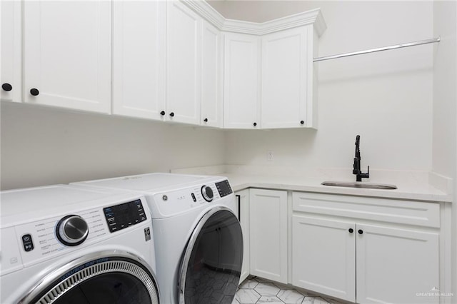 laundry room featuring cabinet space, a sink, and separate washer and dryer