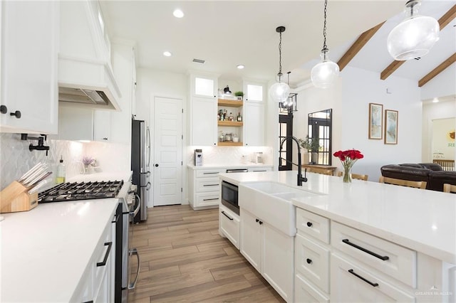 kitchen with white cabinets, open shelves, appliances with stainless steel finishes, and light countertops