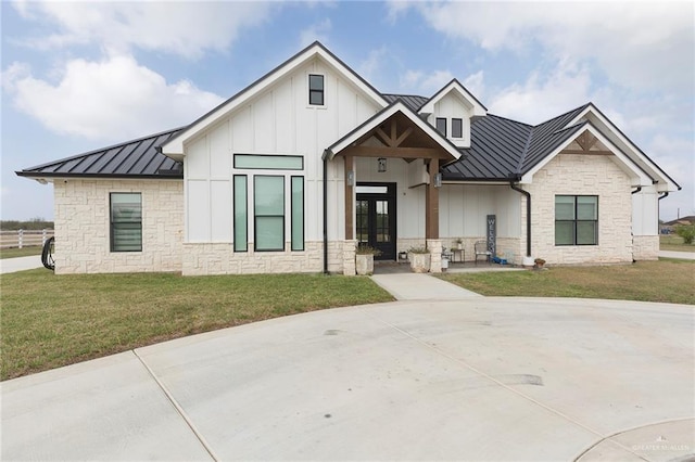 modern farmhouse featuring metal roof, a front lawn, a standing seam roof, and board and batten siding