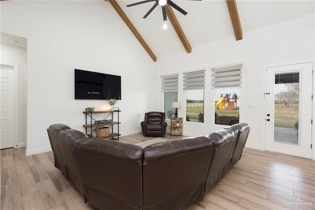 living room with a wealth of natural light, beam ceiling, and light wood finished floors