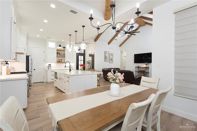 dining space featuring a chandelier, light wood-type flooring, beam ceiling, and visible vents