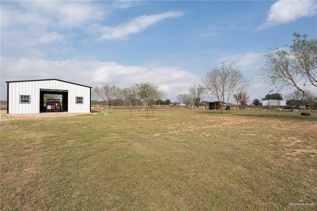 view of yard with a garage, an outbuilding, and a pole building