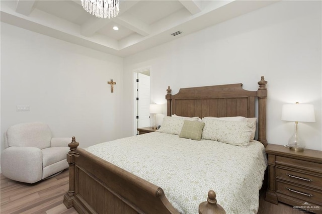 bedroom with a chandelier, coffered ceiling, wood finished floors, visible vents, and beamed ceiling