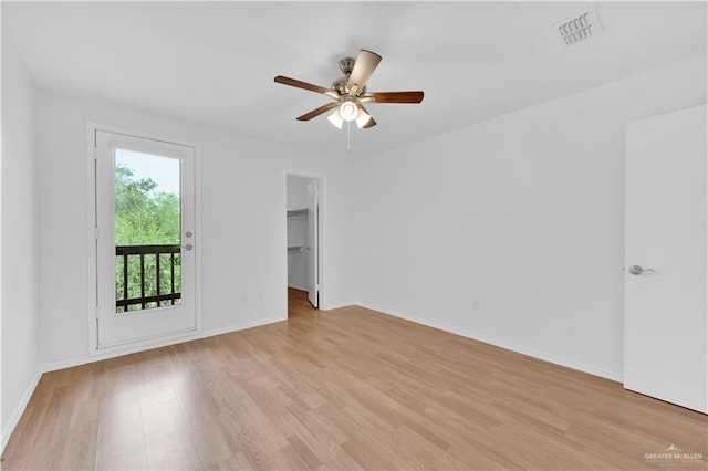 spare room featuring a ceiling fan, baseboards, visible vents, and light wood finished floors