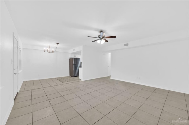 spare room with baseboards, ceiling fan with notable chandelier, light tile patterned flooring, and visible vents