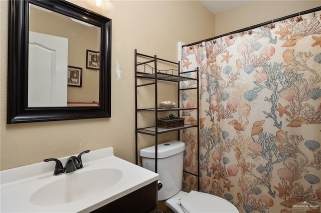 bathroom with vanity, a shower with shower curtain, and toilet