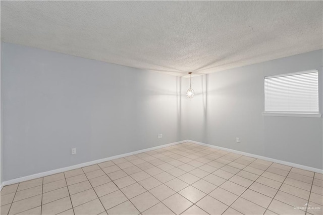 tiled spare room with a textured ceiling