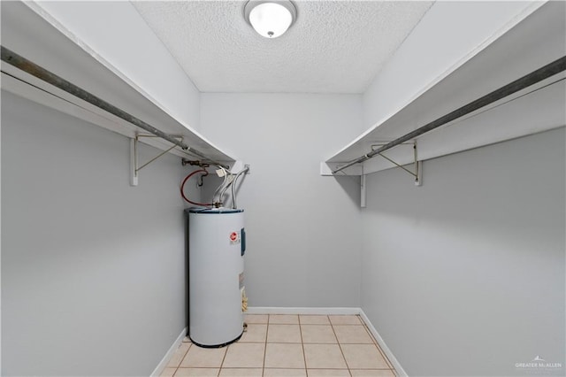 walk in closet with light tile patterned floors and water heater