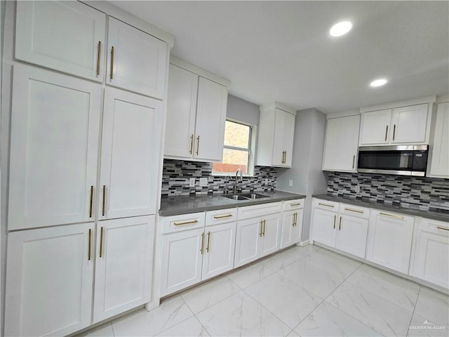 kitchen featuring sink, white cabinets, and decorative backsplash