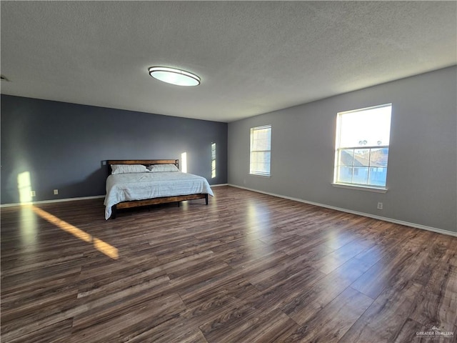 bedroom featuring dark wood-type flooring and a textured ceiling