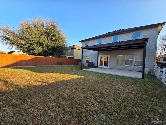 rear view of property featuring a yard, a patio, and central air condition unit