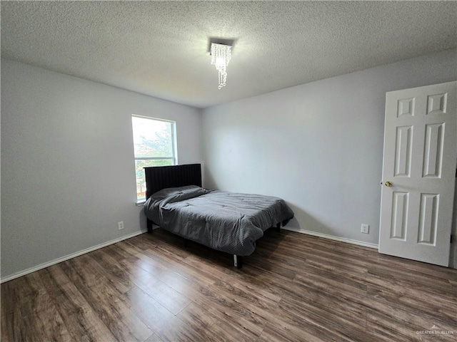 bedroom with dark hardwood / wood-style flooring and a textured ceiling