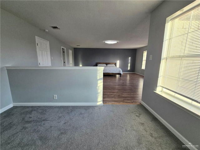 interior space with dark carpet and a textured ceiling