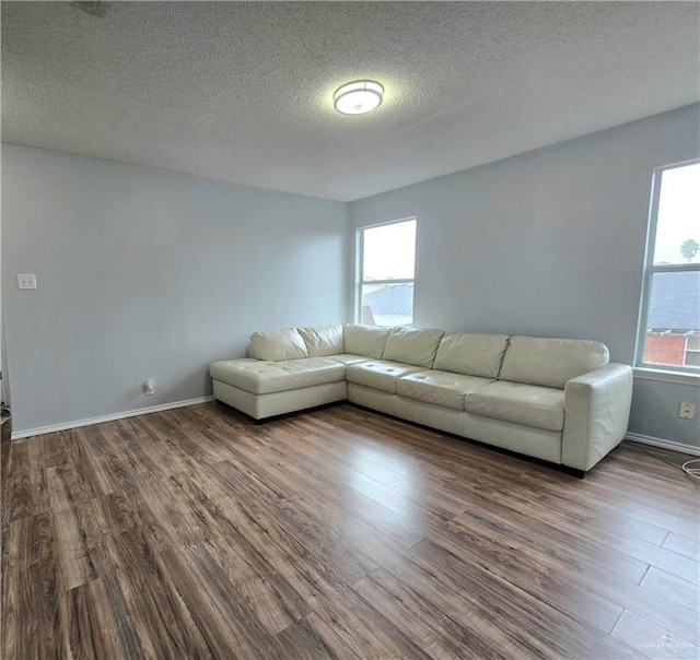 unfurnished living room with hardwood / wood-style floors and a textured ceiling