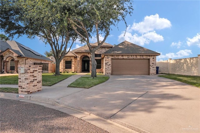 2600 Northgate Ln, Mcallen, TX 78504 - ranch-style home featuring a front yard, brick siding, fence, concrete driveway, and an attached garage