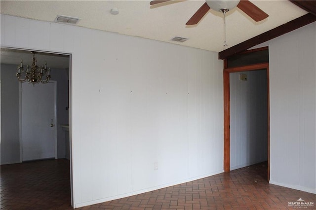 empty room featuring ceiling fan with notable chandelier and vaulted ceiling