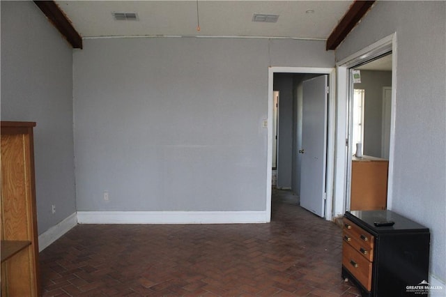 empty room featuring beam ceiling