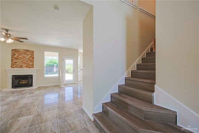 stairs featuring ceiling fan