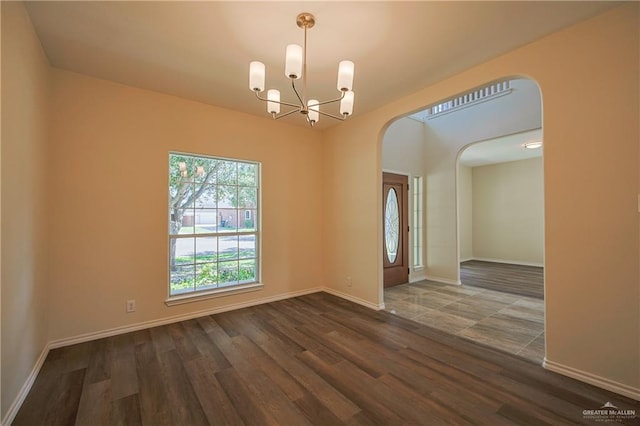 unfurnished room featuring dark hardwood / wood-style floors and an inviting chandelier