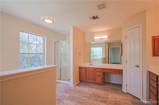 bathroom with vanity, walk in shower, and a wealth of natural light