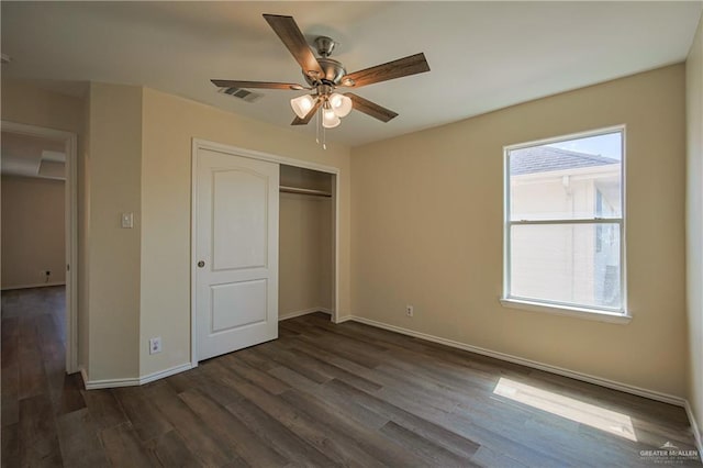 unfurnished bedroom with multiple windows, a closet, ceiling fan, and dark wood-type flooring