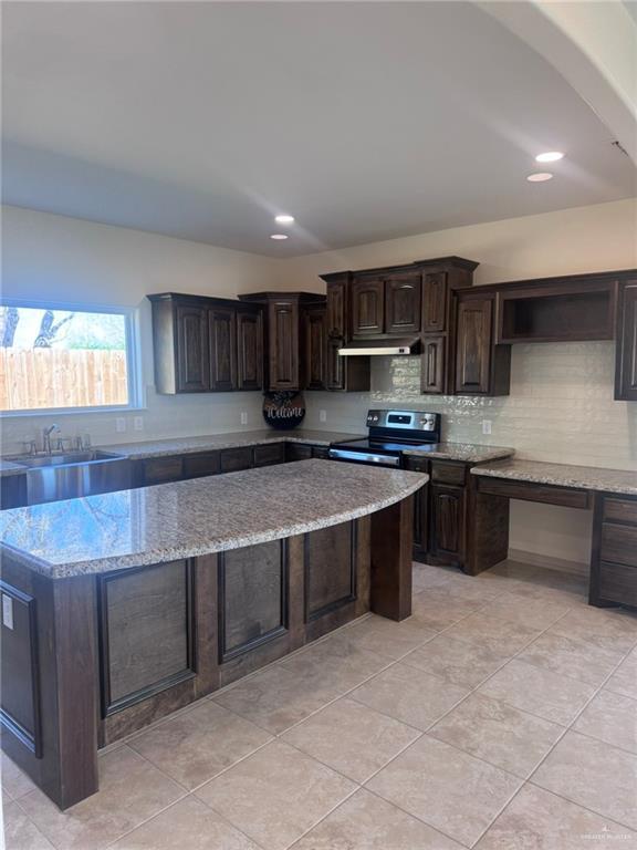 tiled bedroom with connected bathroom, ceiling fan, and sink