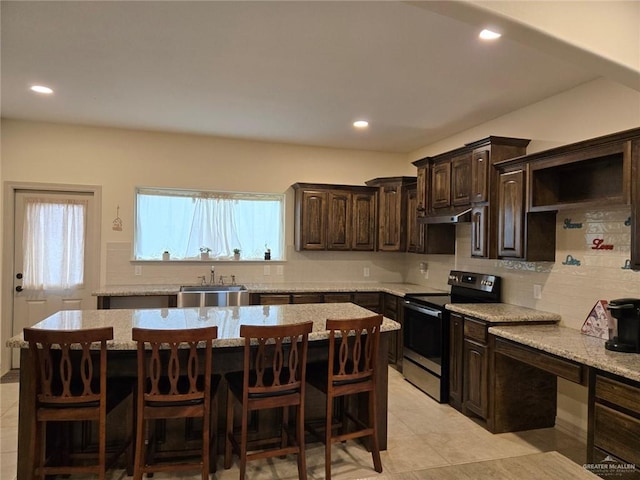 kitchen with stainless steel electric stove, dark brown cabinetry, and a center island