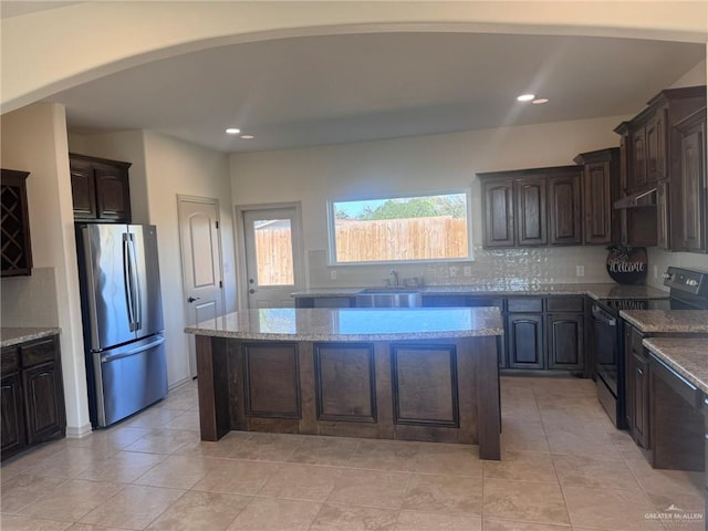 kitchen with freestanding refrigerator, a sink, black range with electric stovetop, and dark brown cabinets