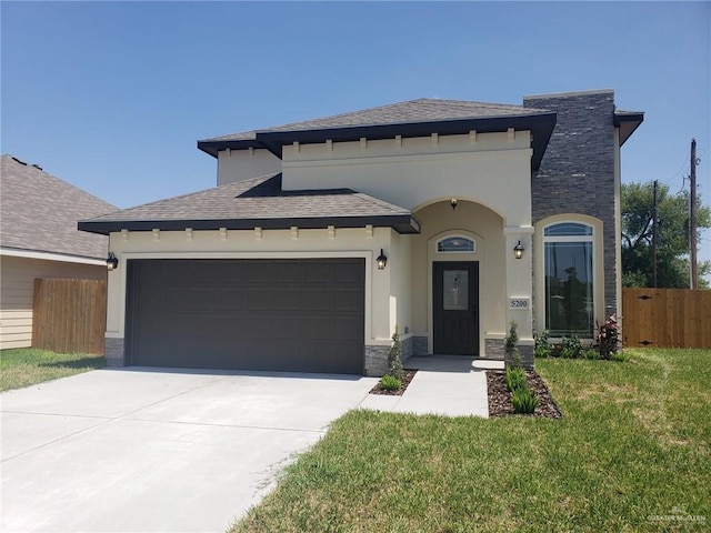 view of front of home featuring a garage, concrete driveway, stone siding, fence, and stucco siding