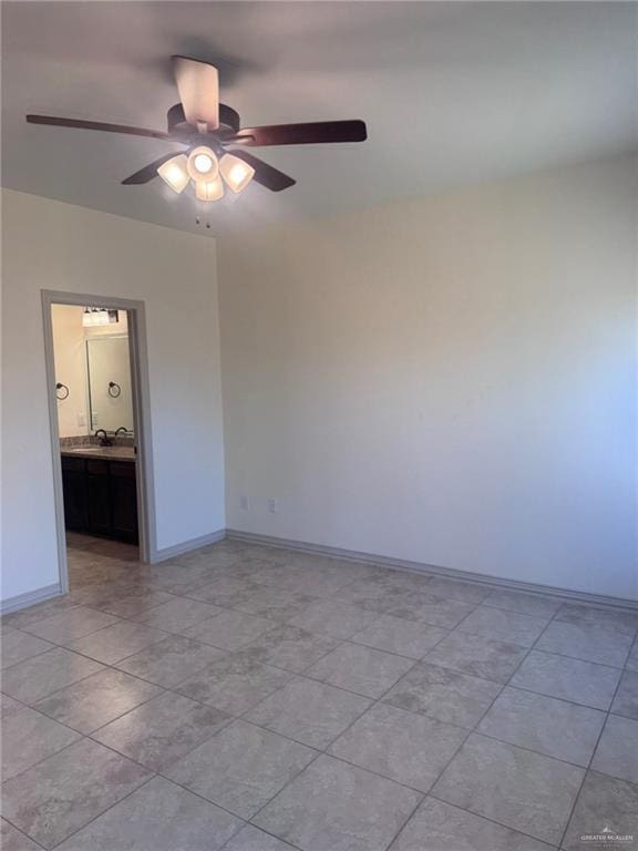 unfurnished room featuring a sink, baseboards, and a ceiling fan