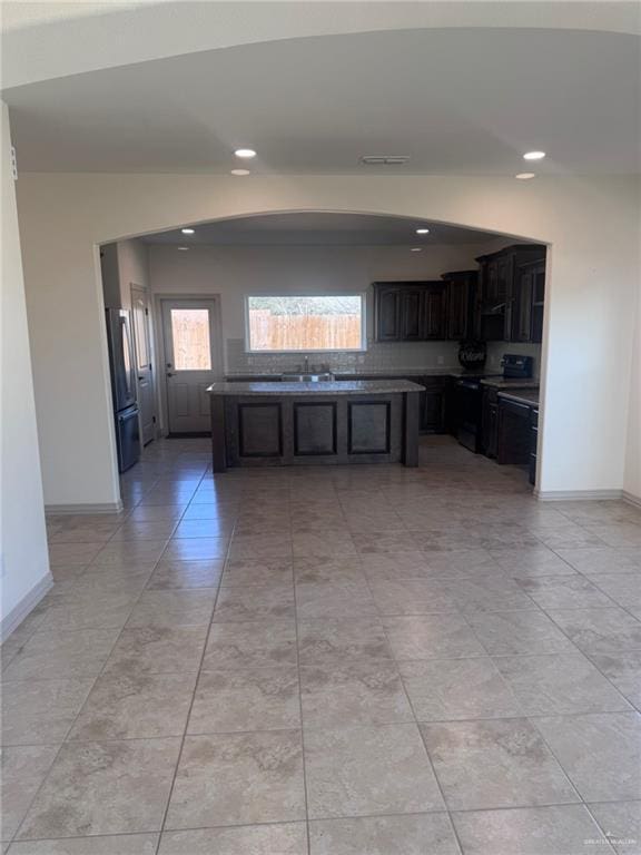 kitchen with freestanding refrigerator, range with electric stovetop, baseboards, and recessed lighting