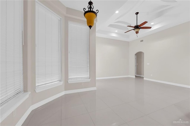 1410 Lobelia St, Weslaco, TX 78599 - tiled empty room featuring arched walkways, ceiling fan, recessed lighting, and a raised ceiling