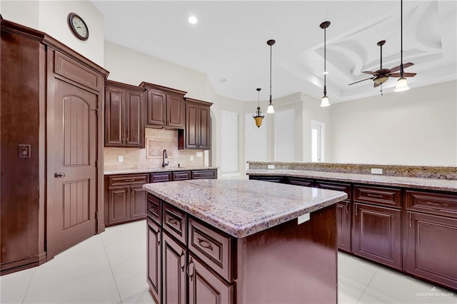 1410 Lobelia St, Weslaco, TX 78599 - kitchen featuring a kitchen island, decorative backsplash, hanging light fixtures, a tray ceiling, and light tile patterned flooring