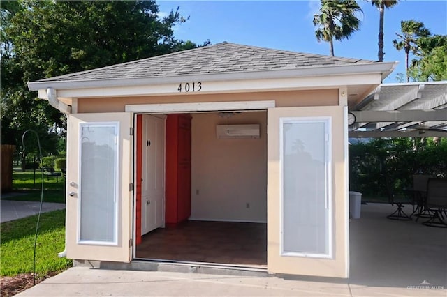 view of outdoor structure with a pergola and an AC wall unit