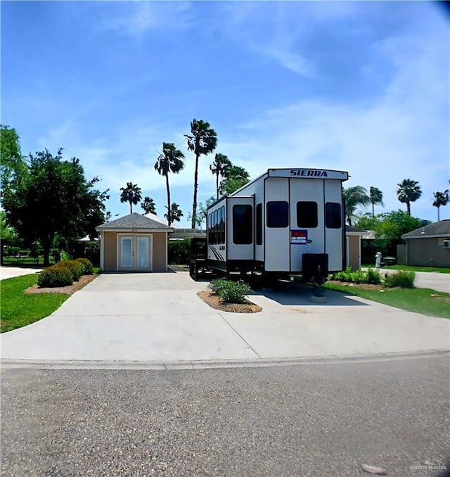 manufactured / mobile home featuring french doors and concrete driveway