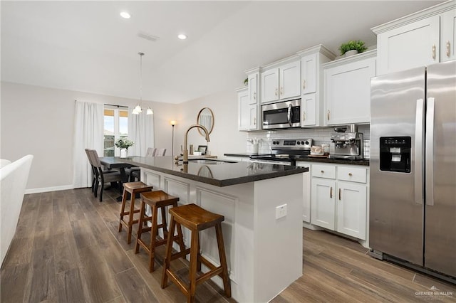 7719 N 39th Ln, Mcallen, TX 78504 - kitchen featuring appliances with stainless steel finishes, a sink, dark wood-type flooring, a kitchen island with sink, and recessed lighting